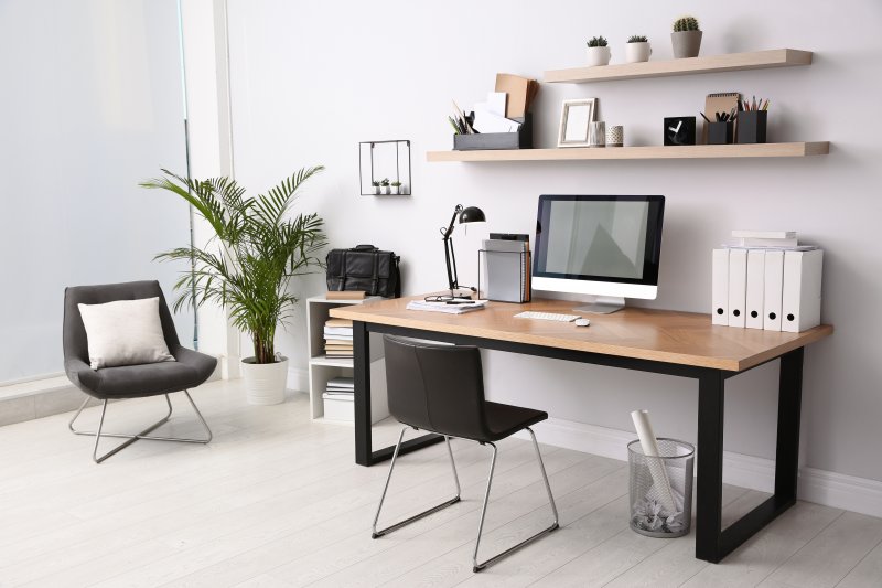 Modern and clutter free home office with a wooden desk and plenty of shelves and storage for papers and personal items (Photo by New Africa - stock.adobe.com)